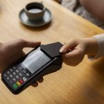 high-angle-customer-paying-with-nfc-device