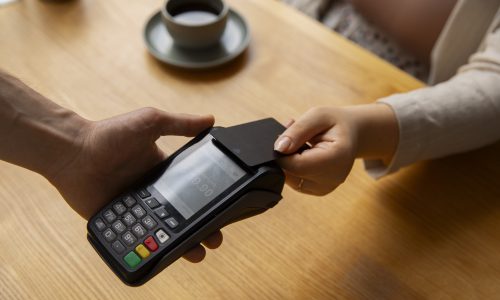 high-angle-customer-paying-with-nfc-device