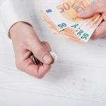 Man holding bank-notes and coins
