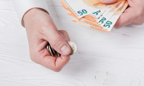 Man holding bank-notes and coins