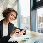 cégvezető nő irodájában mobillal