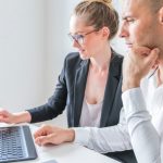 cégvezetők laptop képernyőjét nézik