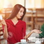 piros ruhás fiatal nő digitálisan bankol